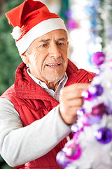 Image showing Male Owner Decorating Christmas Tree At Store