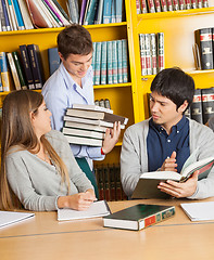 Image showing Student Carrying Books While Friends Sitting In Library