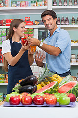 Image showing Male Customer With Saleswoman Comparing Bellpepper At Supermarke