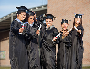 Image showing Graduate Students Holding Certificates On University Campus