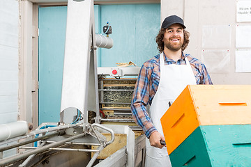 Image showing Beekeeper Holding Trolley Of Stacked Honeycomb Crates