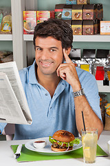 Image showing Male Customer With Snacks And Newspaper In Supermarket