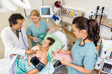 Image showing Doctor And Nurses Examining Patient In Hospital