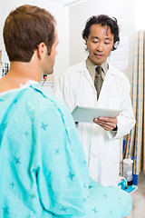 Image showing Doctor Holding Digital Tablet While Discussing Medical Report Wi