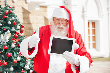 Image showing Santa Claus Gesturing Thumbsup While Holding Digital Tablet