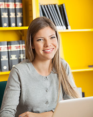 Image showing Student With Laptop Smiling Against Bookshelf In College Library