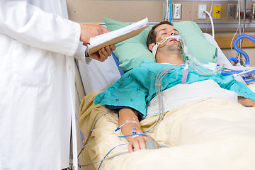 Image showing Doctor Examining Male Patient's Test Report