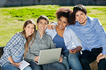 Image showing Students With Laptop And Book Sitting In College Campus