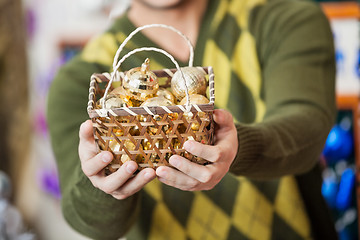 Image showing Man Holding Bauble Basket In Store