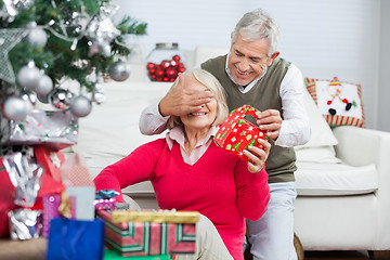 Image showing Happy Man Covering Woman's Eyes While Giving Christmas Gift