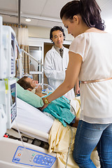 Image showing Doctor Looking At Woman Standing By Patient's Bed