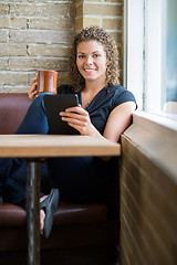 Image showing Woman With Digital Tablet And Coffee Mug In Cafeteria