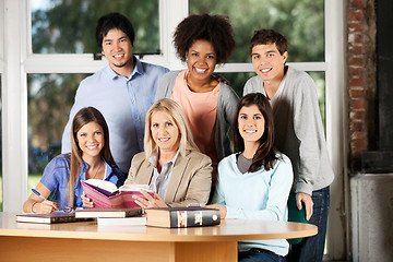 Image showing Students And Teacher With Books Smiling In Classroom