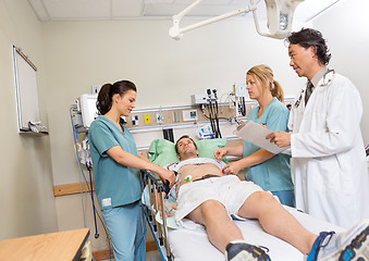 Image showing Doctor And Nurses Checking Patient In Hospital