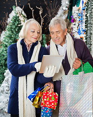 Image showing Senior Couple Using Digital Tablet At Christmas Store