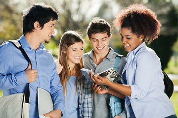 Image showing Students Reading Book Together In Campus