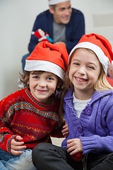 Image showing Happy Siblings Wearing Santa Hats At Home