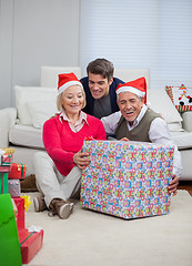 Image showing Man With Parents Holding Christmas Present