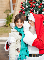Image showing Santa Claus Whispering In Boy's Ear