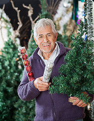 Image showing Man Holding At Christmas Tree And Baubles In Store