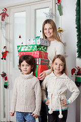 Image showing Family With Gifts Standing By Door During Christmas