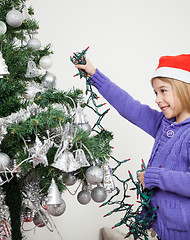 Image showing Girl Decorating Christmas Tree With Fairy Lights