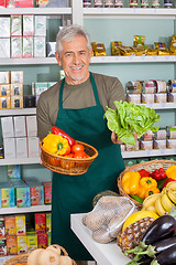 Image showing Senior Salesman Selling Vegetables In Supermarket
