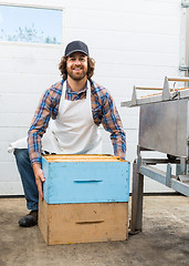 Image showing Male Beekeeper With Honeycomb Boxes In Factory