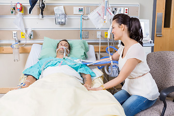 Image showing Woman Looking At Man Lying On Bed