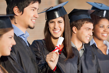 Image showing Graduate Student Holding Diploma While Standing With Friends At