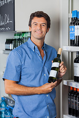 Image showing Man Displaying Wine Bottle In Supermarket