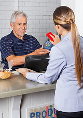 Image showing Female Customer Paying Through Mobile Phone In Store