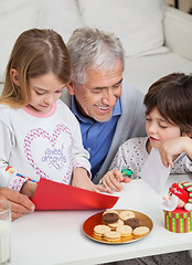 Image showing Smiling Man Assisting Children In Making Greeting Card