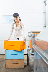 Image showing Beekeeper With Stacked Honeycomb Boxes Working In Factory