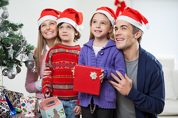 Image showing Family In Santa Hats With Christmas Gift