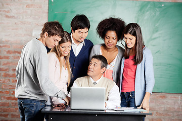 Image showing Teacher With Laptop Explaining Lesson To Students In Classroom