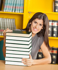 Image showing Student With Piled Books Sitting At Table In Library