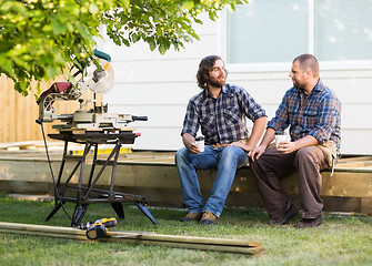 Image showing Carpenters With Disposable Cups Looking At Each Other On Frame