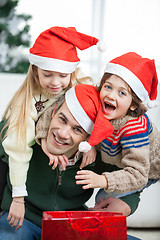 Image showing Father Piggybacking Children During Christmas