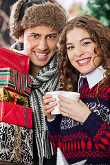 Image showing Couple With Disposable Cups And Christmas Presents