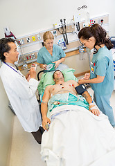 Image showing Nurses And Doctor Examining Critical Male Patient