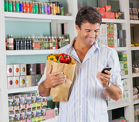 Image showing Man With Paper Bag Using Mobile Phone In Supermarket