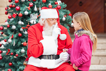 Image showing Girl Looking At Santa Claus Gesturing Finger On Lips