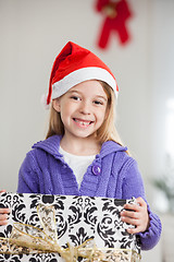 Image showing Girl In Santa Hat Holding Christmas Gift