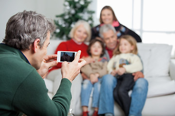 Image showing Father Photographing Family Through Smartphone