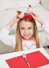 Image showing Happy Girl Holding Santa Headband