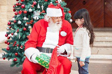 Image showing Santa Claus Giving Gift To Girl