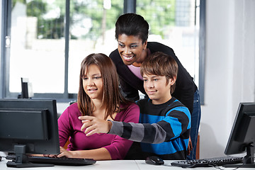 Image showing Teacher Assisting Teenage Students In Computer Lab