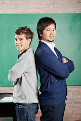 Image showing Male Students Standing Hands Folded Against Greenboard In Classr