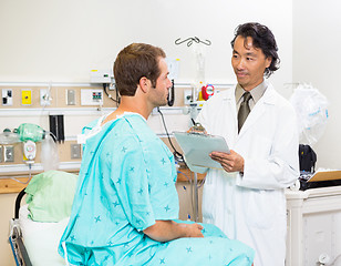 Image showing Doctor With Clipboard Discussing Medical Report In Hospital